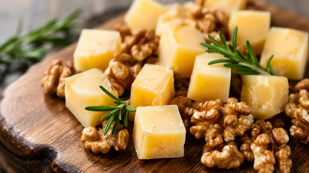 Käsewürfel mit Walnüssen und Rosmarin auf Holzbrett