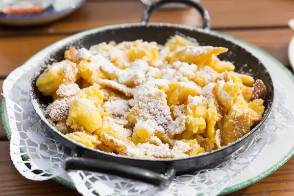 Kaiserschmarrn in der Pfanne serviert: typische Süßspeise der österreichischen Küche