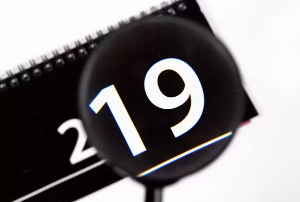 Kalender 2019 betrachtet durch Leselupe vor weißem Hintergrund