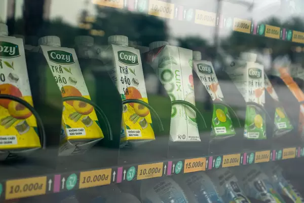 Kalte Getränke in Tetra Paks und Flaschen in einem Getränkeautomaten mit Preisen und Nummern in einem Öffentlichen Park