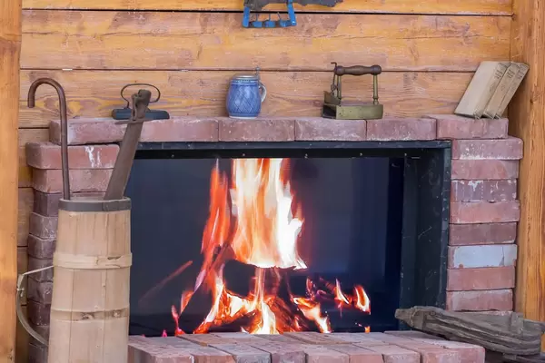Kaminfeuer umrahmt mit Backsteinen und antiken Objekten