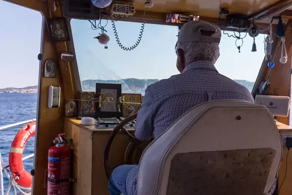 Kapitän am Schiffssteuer auf dem Myrtoischen Meer