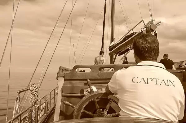 Käpt'n hält das Steuer eines Schiffskutters auf hoher See