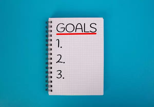 Karo-Ringblock mit der Aufschrift "Goals" - Ziele -  vor einem blauen Hintergrund