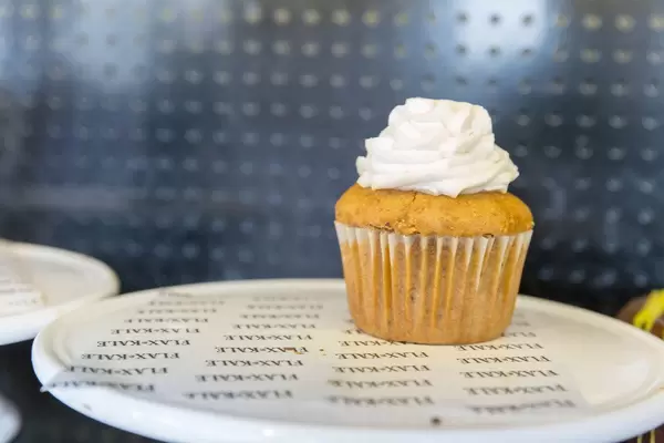 Karotten-Kokosnuss Cupcake aus Vollkornreis und Buchweizenmehl mit Zimt, Apfel, Muskatnuss und weißem Topping im Flax&Kale in Barcelona, Spanien