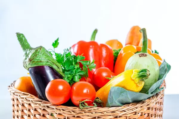 Karotten, Paprika, Balajan-Tomaten,  Zucchini und Petersilie in einem Weidenkorb in der Nahaufnahme