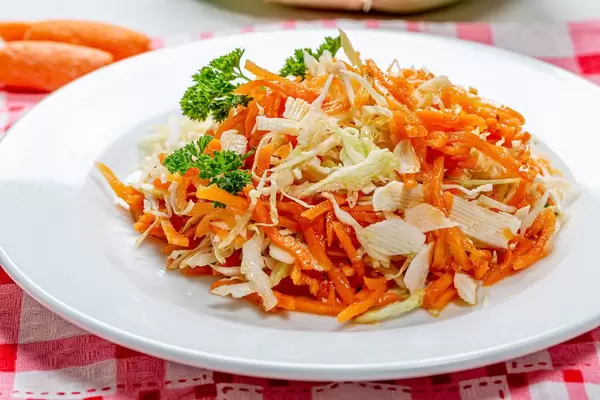 Karotten- und Krautsalat auf weißem Teller in der Nahaufnahme für eine gesunde Ernährung