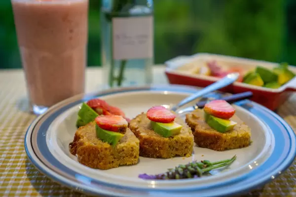 Karottenkuchen mit Erdbeer-und Avocadoscheiben auf einem Teller Nahaufnahme