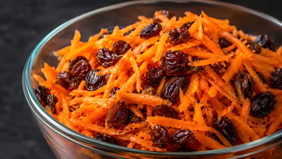 Karottensalat mit Rosinen in Glasschüssel
