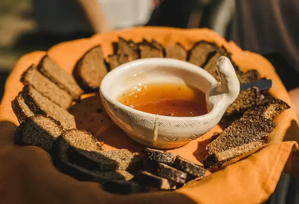 Keramikschale / Honigtopf umgeben von rustikalen Brotscheiben