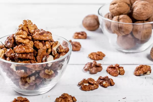 Kernel walnuts and whole with shell on white boards