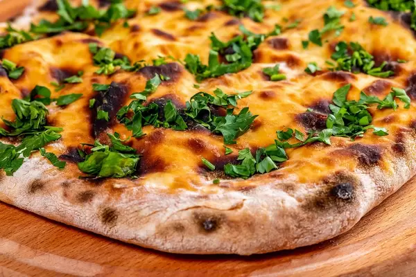 Khachapuri with cheese and herbs on wooden kitchen Board (Flip 2019)