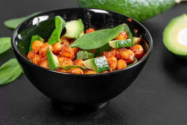 Kichererbsen in Tomatensoße, Avocadostücken und Spinat