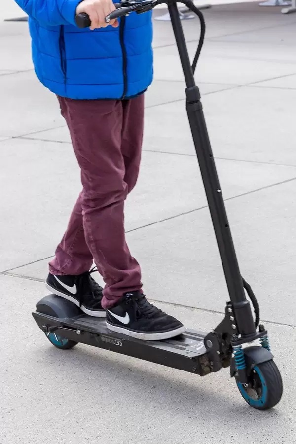 Kid rides a black Egret One e-scooter at the E-Cologne trade show for sustainable mobility in Germany