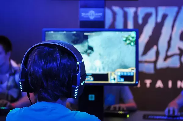 Kind mit leuchtenden Kopfhörern zockt Videospiele