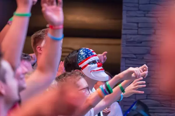 Kind mit Payday 2 Maske wartet auf geworfene Merch-Artikel