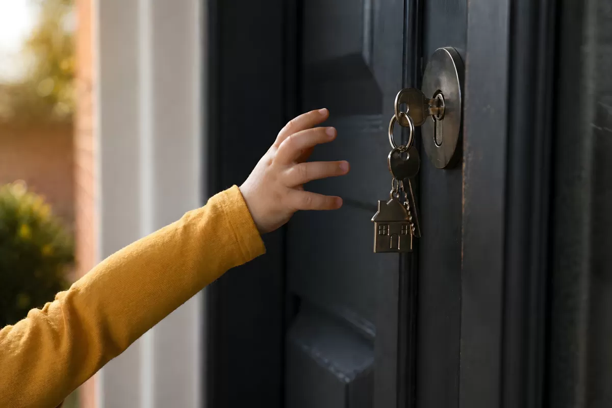 Kinderhand greift nach Schlüssel in Haustür