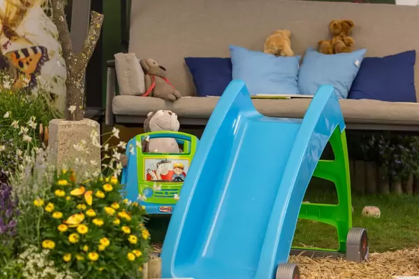 Kinderrutschbahn, Spielzeug und Hollywoodschaukel im Garten