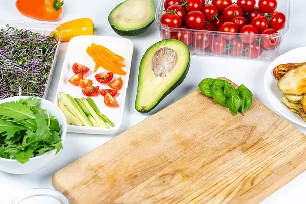 Kitchen table with fresh vegetables, herbs and fried zucchini