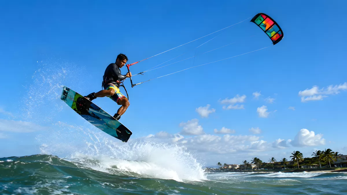 Kitesurfer springt über Wellen an tropischer Küste