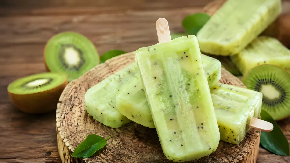 Kiwi-Eis am Stiel auf rustikalem Holzbrett