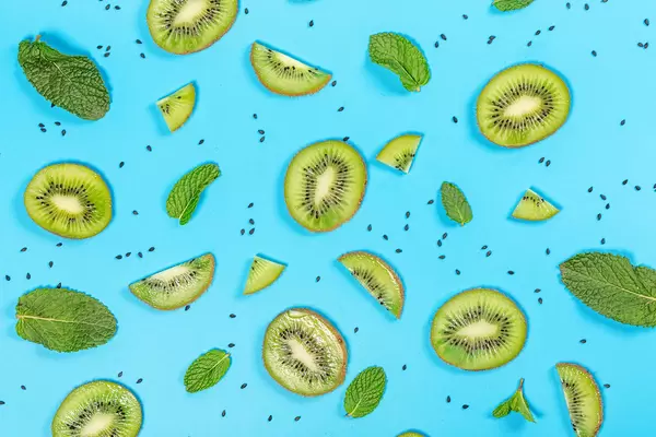 Kiwi slices with mint leaves on a blue background