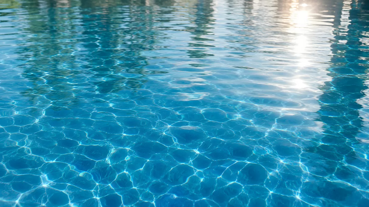 Klares blaues Schwimmbadwasser mit Lichtreflexen