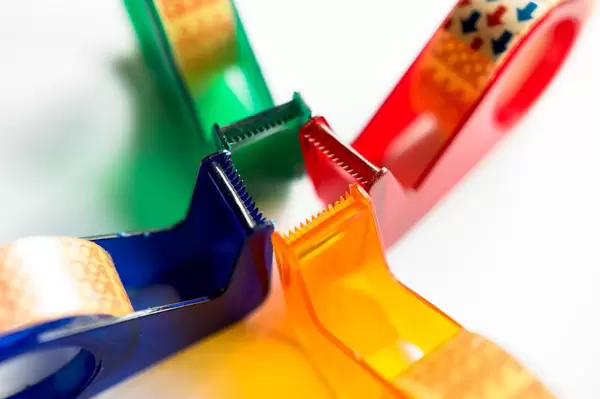 Klebebandabroller verschiedener Farben zeigen Richtung Mitte