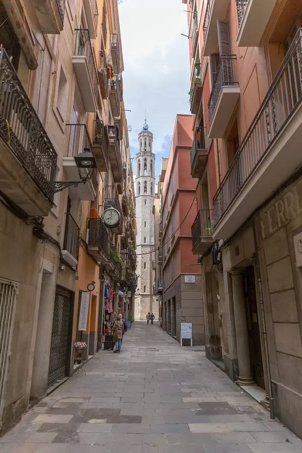 Kleine Gasse zwischen mediterranen Fassaden mit Blick auf die gotische Kirche "Basílica de Santa Maria del Mar" in Barcelona, Spanien