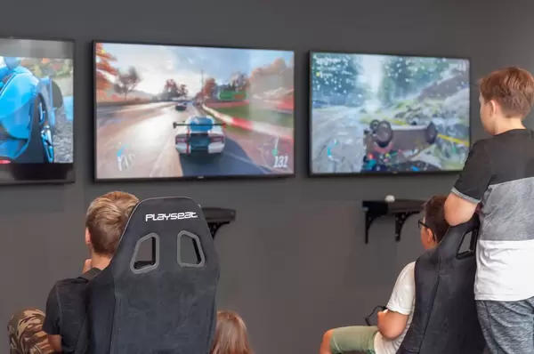 Kleine Jungs zocken ein Rennspiel auf der Xbox One