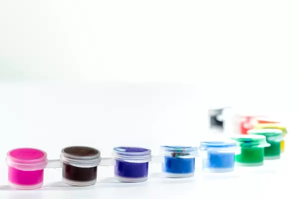 Kleine Pöttchen mit verschiedenen Farben zum Zeichnen vor weißem Hintergrund