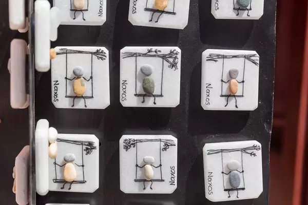 Kleine quadratische Souvenirs von Naxos aus einheimischem Marmor. Figur auf einer Schaukel