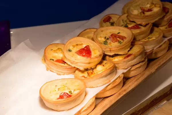 Kleine verschiedene Quichetörtchen rund gestapelt auf der Digital X