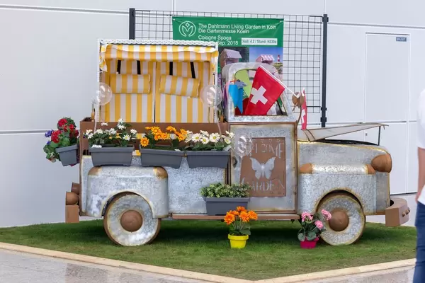 Kleiner Lieferwagen aus Blech mit Blumentöpfen als Garten-Deko