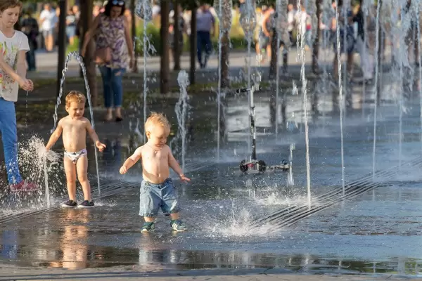 Kleinkinder spielen im Springbrunnen