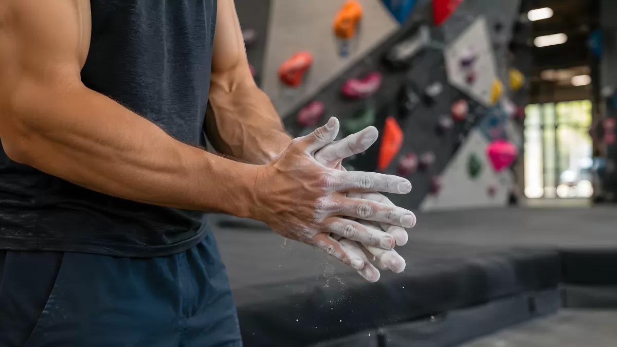 Kletterer reibt Magnesia in Boulderhalle ein