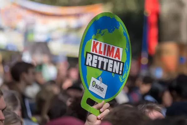 Klima Retten Schild in der Form eines Globus in der Hand eines Demonstranten