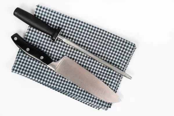 Knife and Knife Sharpener on the kitchen dishcloth on the white background (Flip 2020)