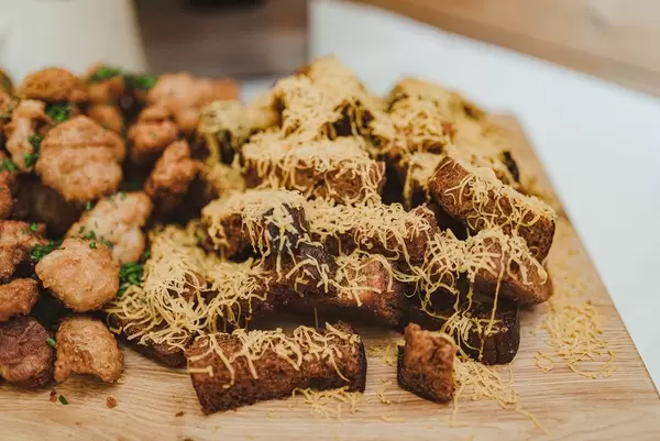Knoblauch-Käse Toast und gebratenes Hunch Snacks auf einem Holztisch
