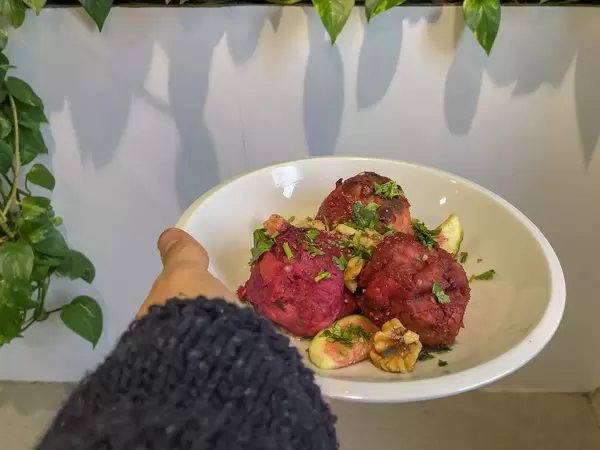 Knödel aus roter Bete, dekoriert mit Feige, Walnüssen und Koriander wird serviert