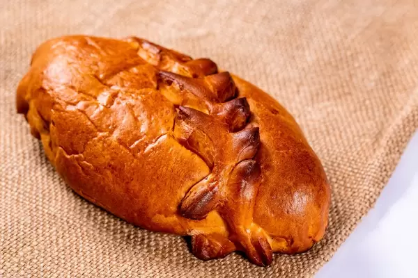 Knusprig gebackener Kirschkuchen mit Zopfmuster auf Jutesack