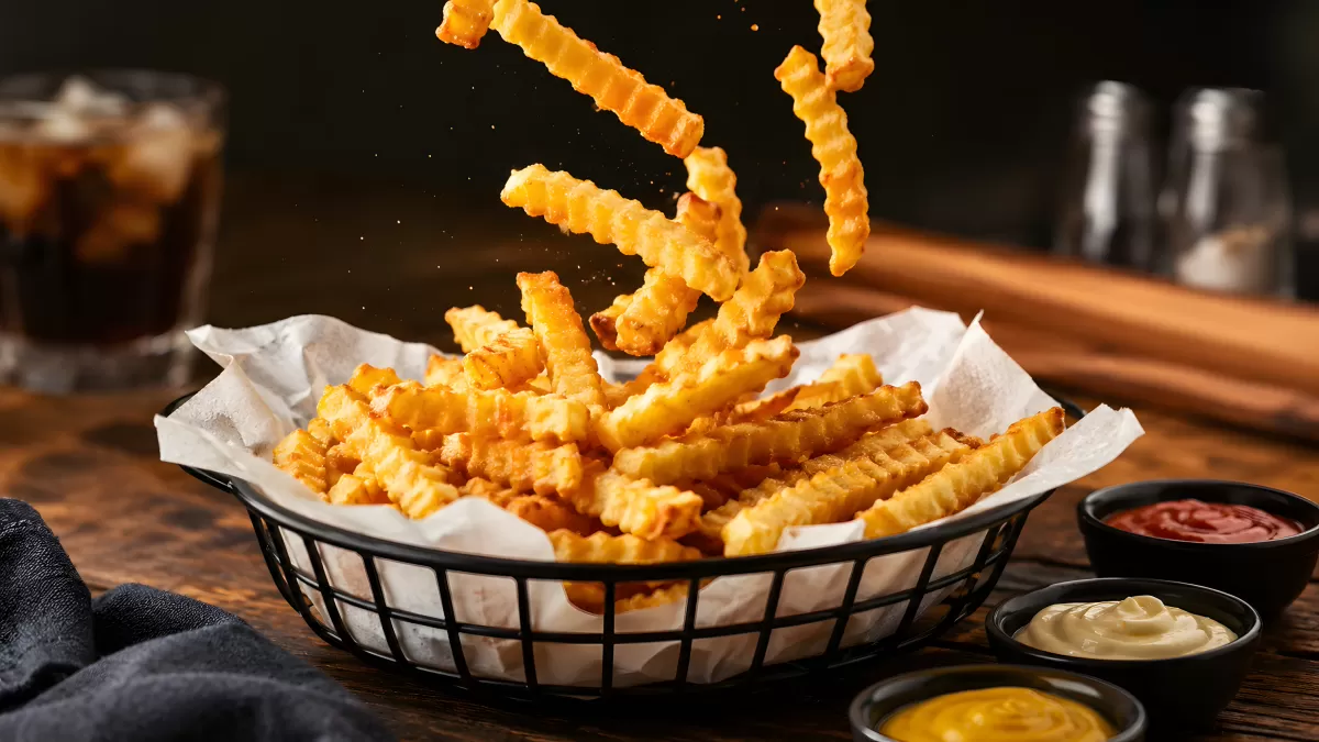 Knusprige Crinkle-Fries im Korb mit Dipsaucen