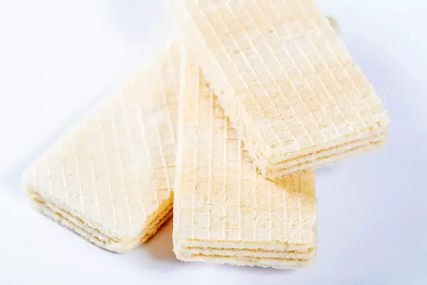 Knusprige weiße Waffeln mit Kokosnuss-Füllung vor weißem Hintergrund