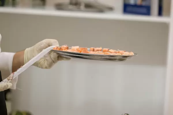 Koch hält eine Platte mit geräuchertem Fisch in der Hand