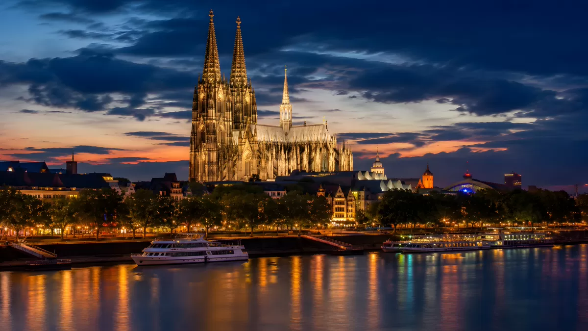 Kölner Dom bei Nacht am Rheinufer im Abendrot