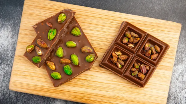 Köstliche Schoko-Pistazien auf hölzernem Servierbrett