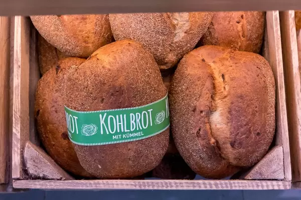 Kohlbrot mit Kümmel: mehrere Brotlaibe in einer alten Holzkiste, aus der Sicht von oben