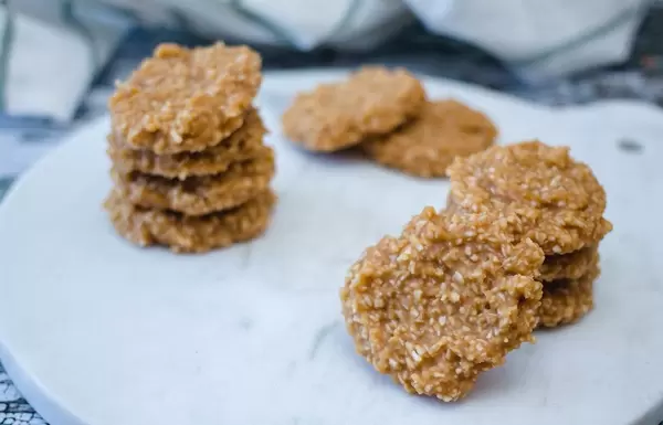 Kokosnusskekse, essbar ohne zu backen, auf einer weißen Platte, als gesunder Snack