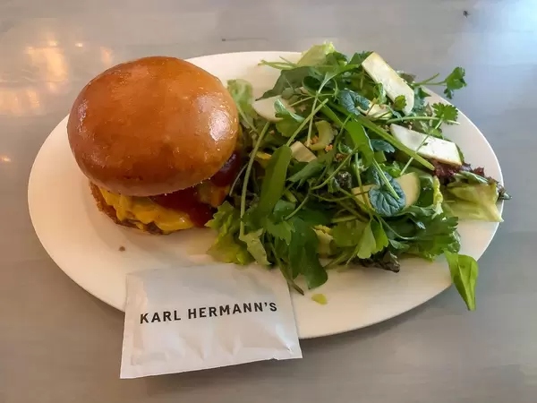 Kölner Burger-Restaurant Karl Hermann's mit Smash-Bacon Cheeseburger aus Schweinefleisch und Farm To Table Salat mit Bio-Kräuter
