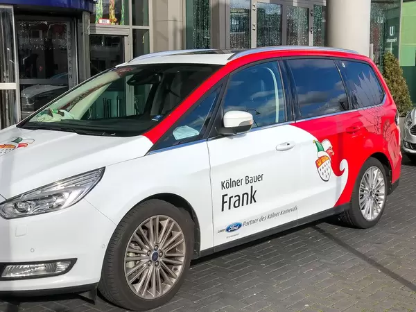 Kölner Karneval: das Auto vom Kölner Bauer Frank im Rot-Weiß mit dem Kölner Wappen